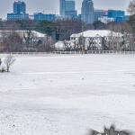 Snow covered NCSU fields along Lake Wheeler Road with downtown Raleigh