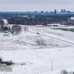 Snow covered NCSU fields along Lake Wheeler Road with downtown Raleigh